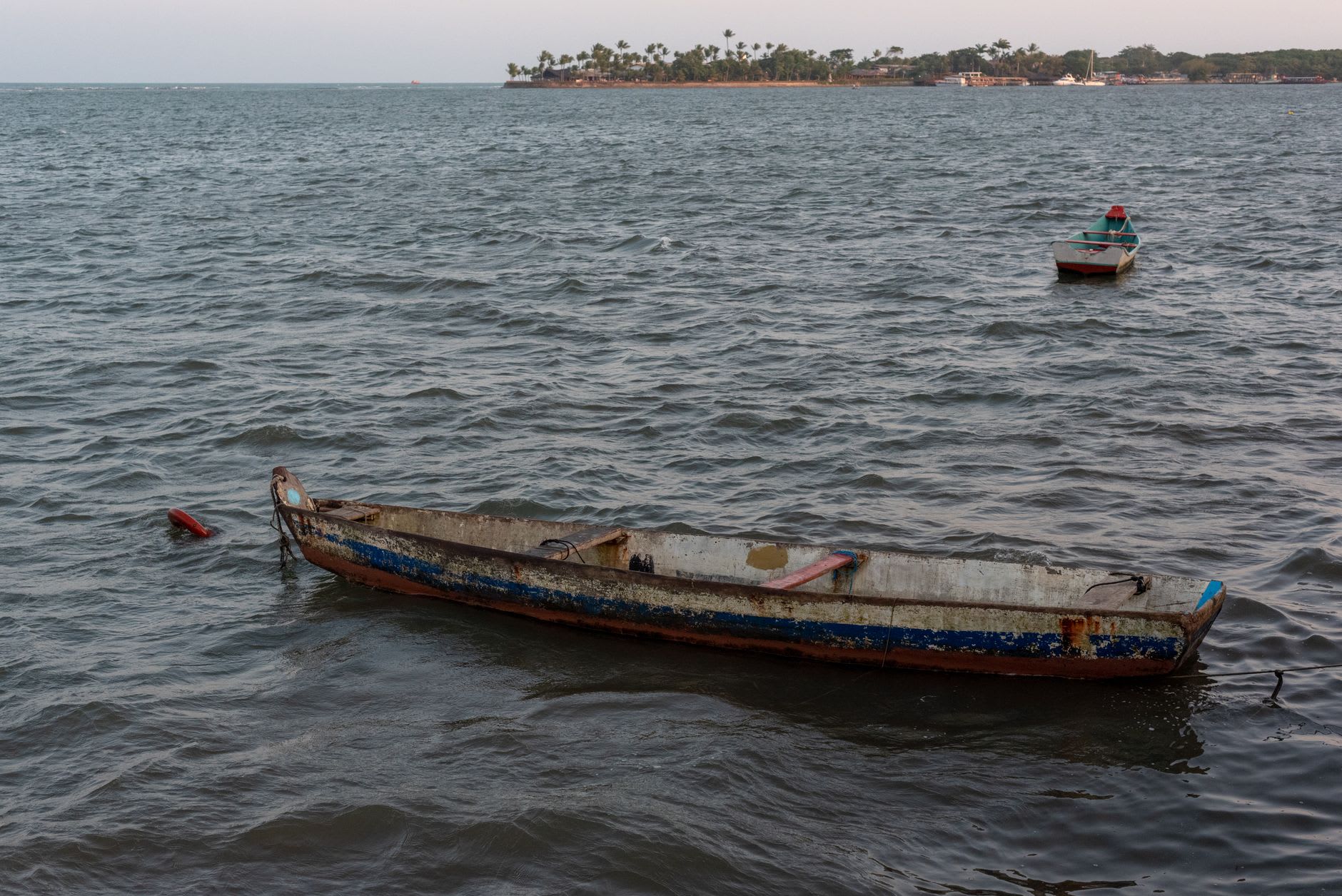 The busy fish market and stalls along the Ponta de Pedras waterfront in the morning, boats unloading behind