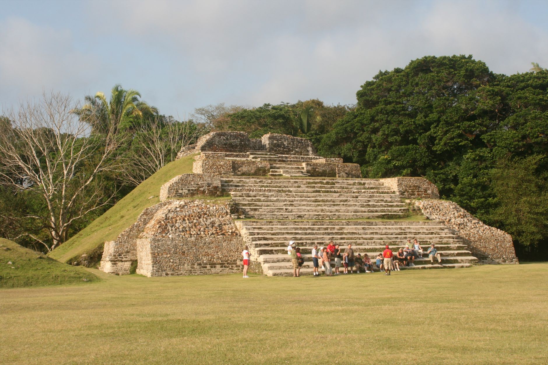 Temple I rising from Tikal's Gran Plaza at dawn, mist clinging to the jungle below