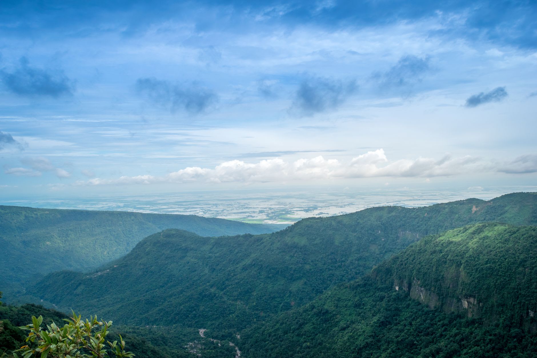 Le champ de pierres dressées à Nartiang, des monolithes de basalte de hauteurs variables disposés à travers une clairière herbeuse, des collines lointaines visibles derrière