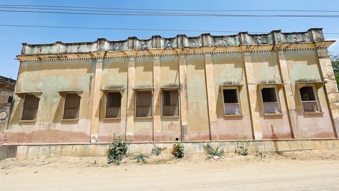L'extérieur en béton criblé d'impacts de balles du musée Amna Suraka à Sulaymaniyah, d'anciens miradors et blocs de prison visibles contre le ciel
