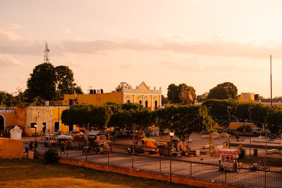 Morning light in the central plaza of Acanceh, with the pyramid visible beside the parish church