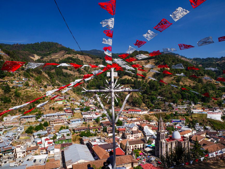 The mining-town streets of Angangueo in the Michoacán sierra, the steep staircase streets between colorful houses, the forest of the monarch butterfly sanctuary visible on the mountain above the town
