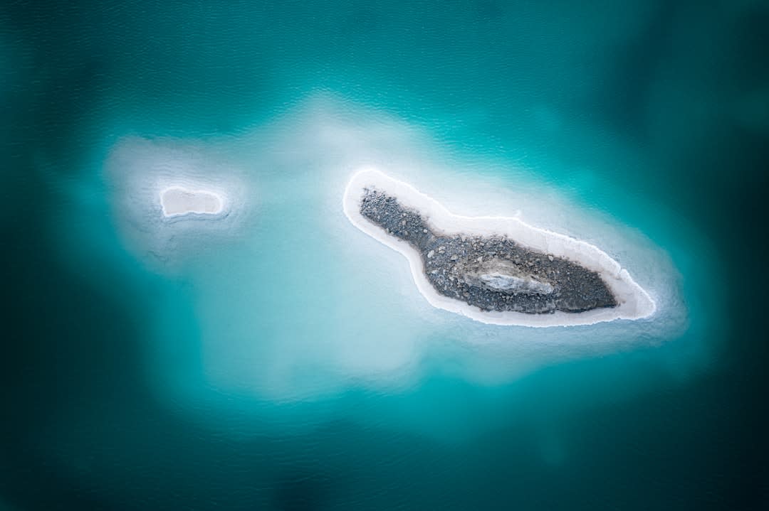 Calm surface of Laguna Bacalar at dawn reflecting soft orange and blue light near the town pier