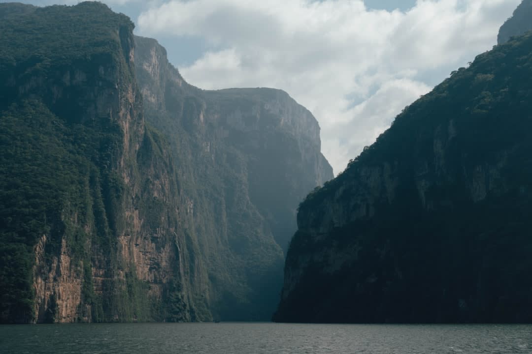 The limestone canyon walls above the El Aguacero pool, layered in grey and amber strata