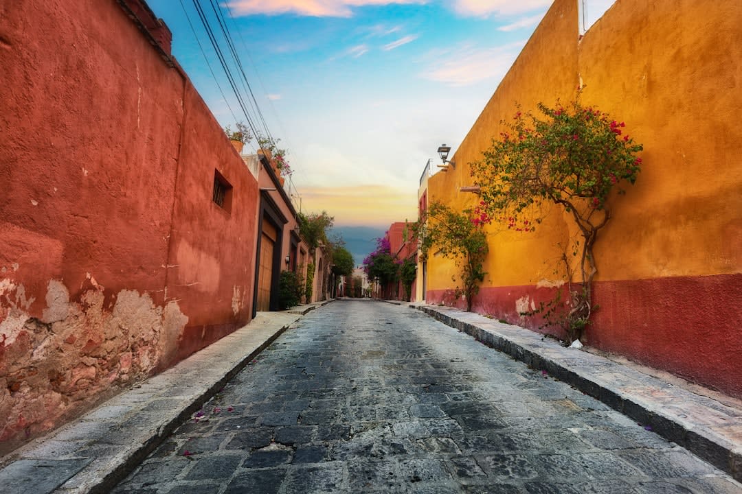 The bastions and defensive walls of Campeche at sunset, the colonial city within glowing in warm light, the Gulf of Mexico flat and silver in the distance