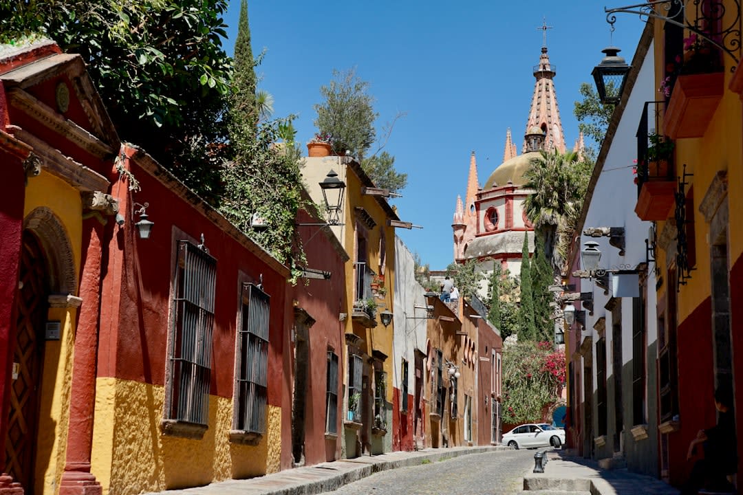 Campeche's pastel-painted colonial street with blue and yellow façades, stone portales and wooden balconies typical of the Gulf coast colonial style