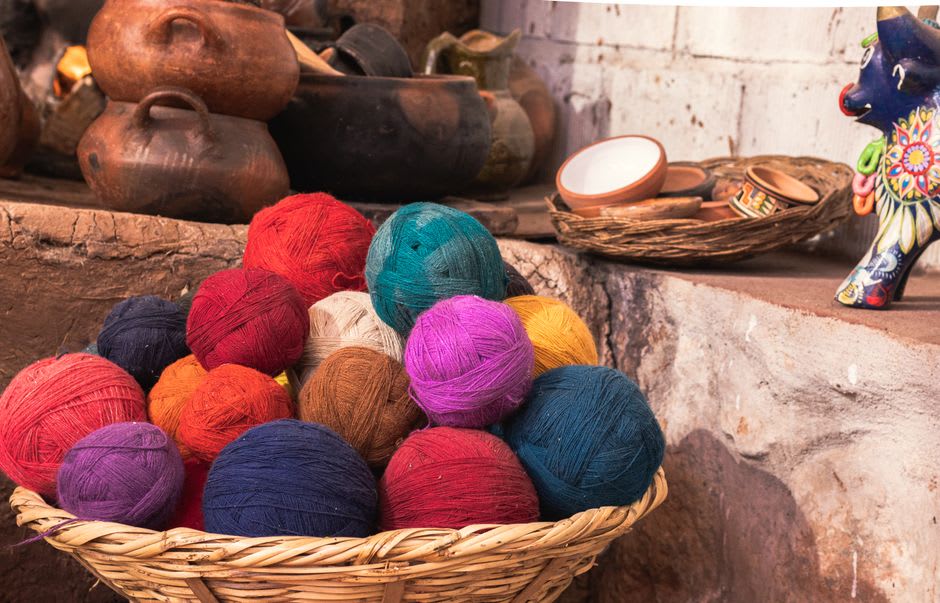 A busy market stall in Chiautempan piled with folded woolen blankets and yarn