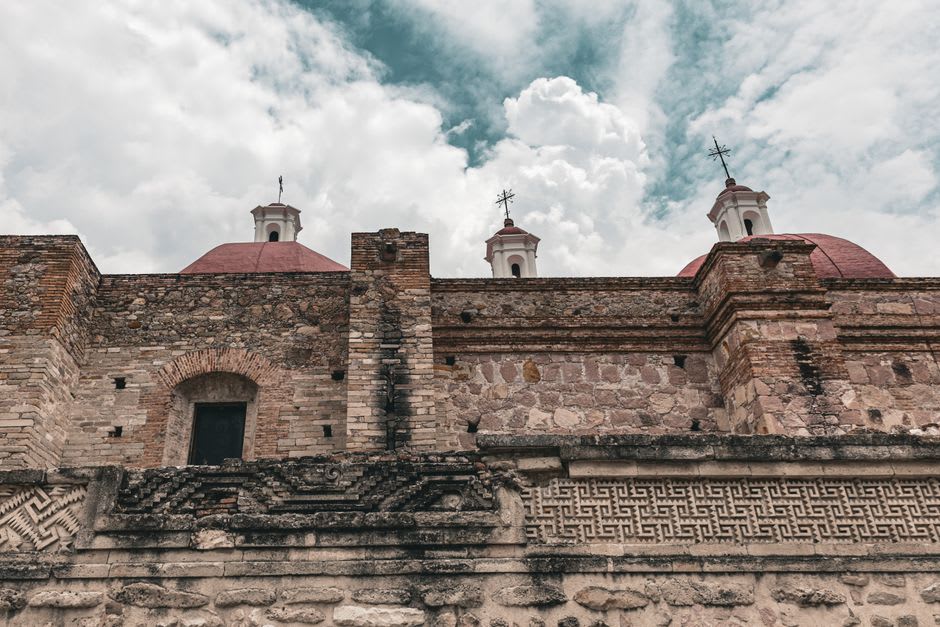 The whitewashed facade of the Parroquia de Santiago Apóstol in Ejutla de Crespo on a Friday morning, market vendors visible below the steps