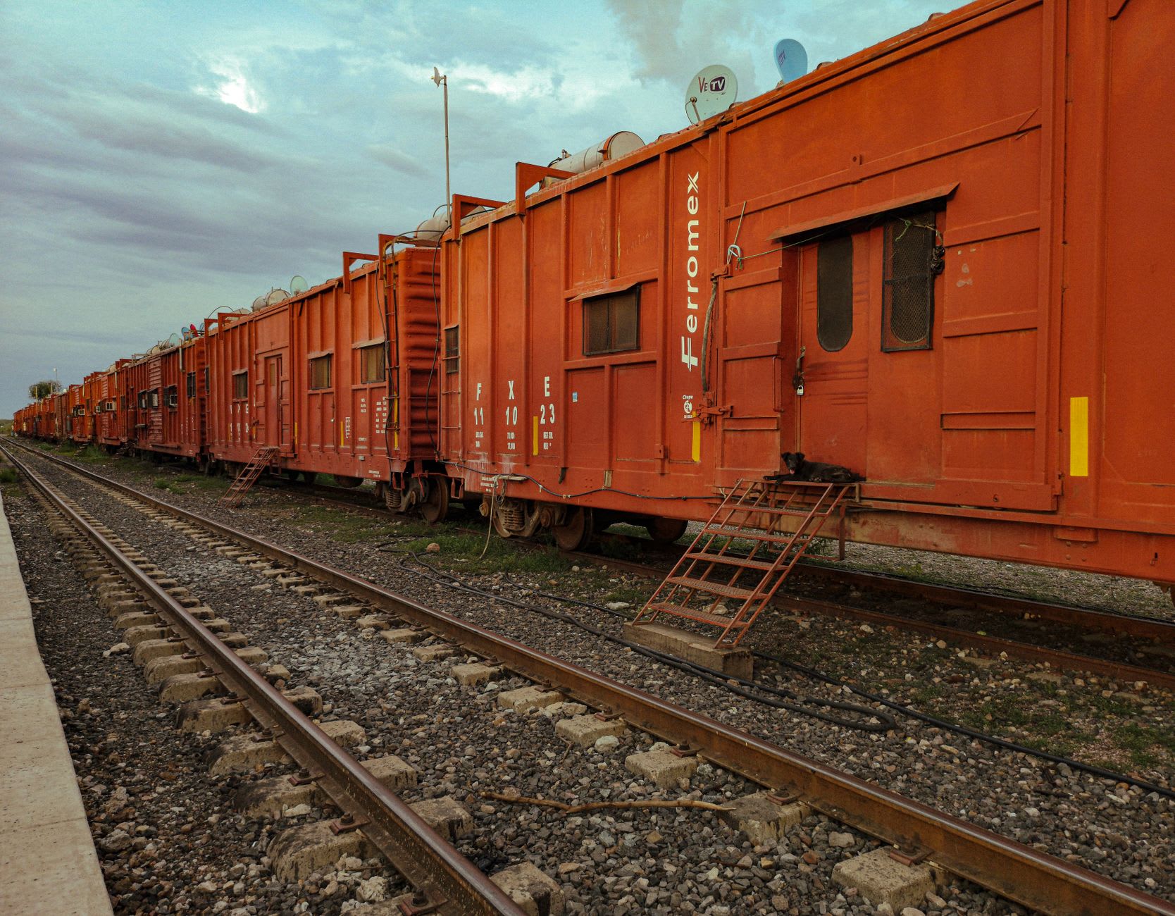 A morning view of the El Chepe train at the El Fuerte station as it prepares to depart east toward the Copper Canyon, the colonial town behind the station, passengers boarding for the journey into the Sierra Tarahumara