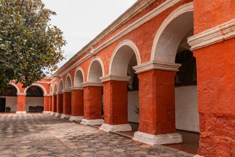 The wide stone atrium of Epazoyucan monastery with its corner capilla posa chapel and a clear blue Hidalgo sky