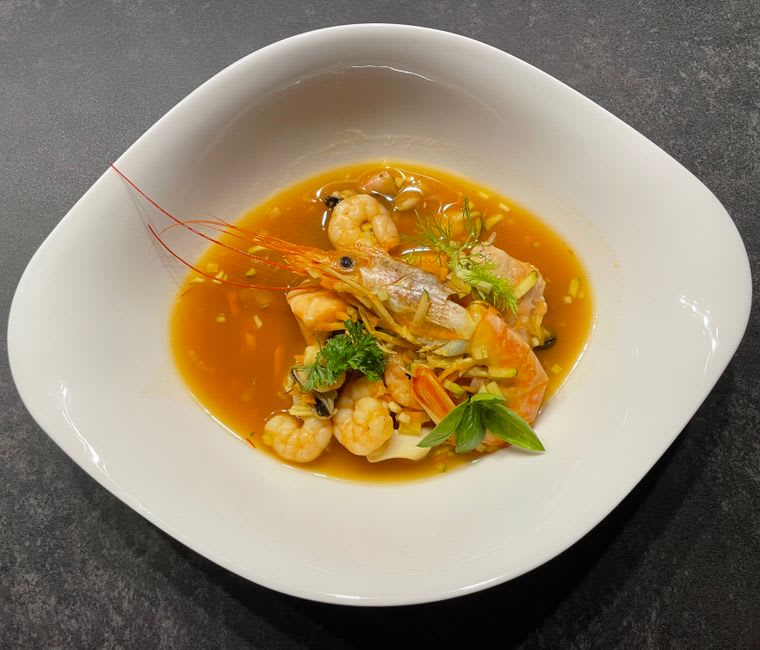 A bowl of caldo de camarón with fresh shrimp and herbs at a market restaurant in Escuinapa