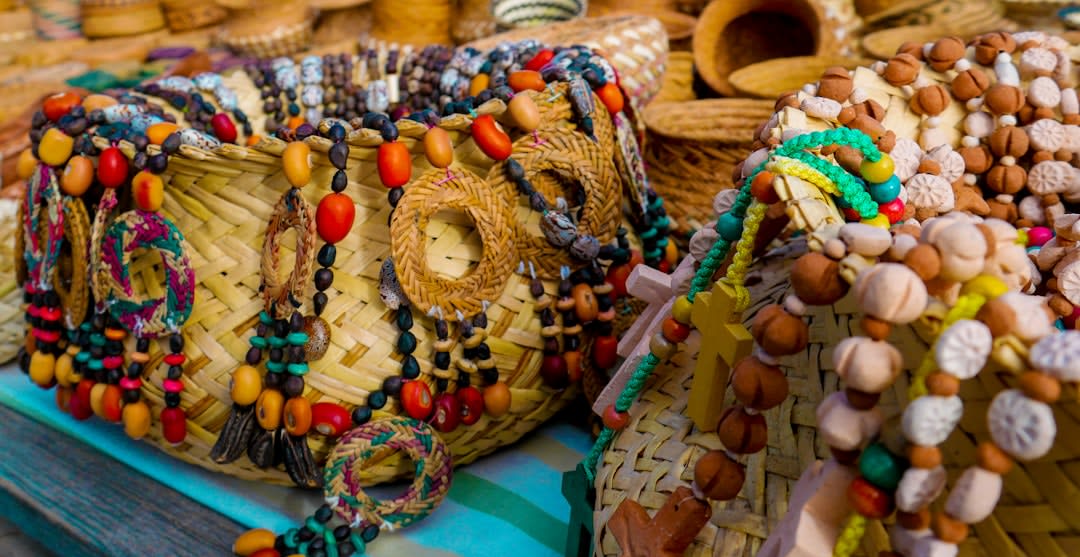 Rarámuri women seated at the Saturday tianguis in Guachochi with pinole and carved wooden figures on cloth