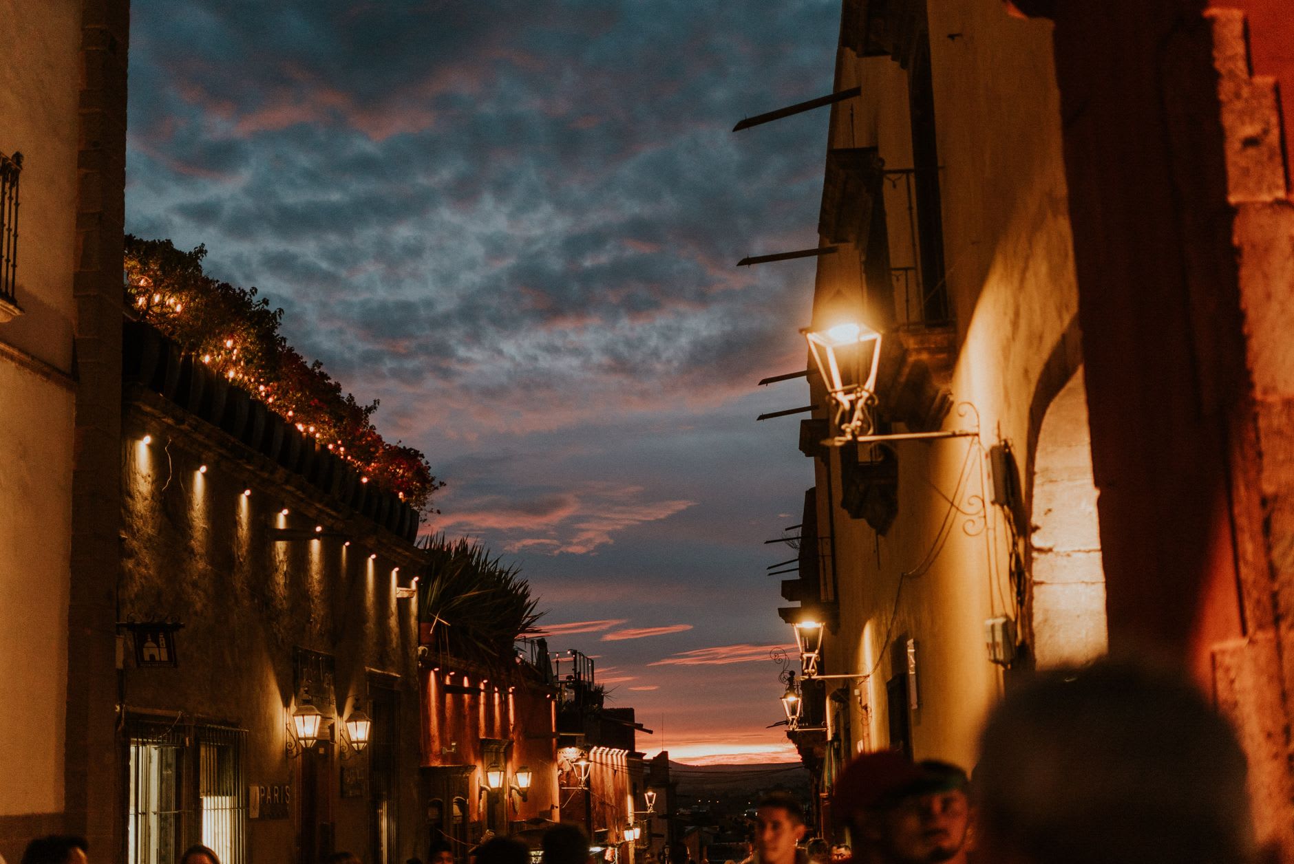 The narrow Callejón del Beso in Guanajuato at early morning, the two opposing balconies nearly touching over the alley, the painted walls in gold and terracotta, the stepped cobblestone passage empty in the early light