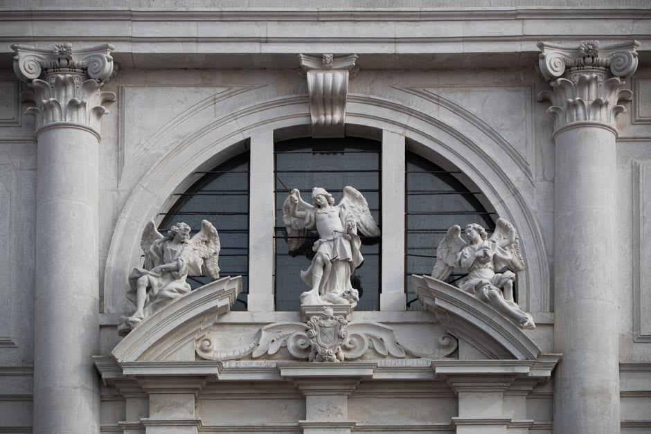 The carved facade of the church of San José del Parral in warm afternoon light, stone saints and ornamental details above the arched entrance