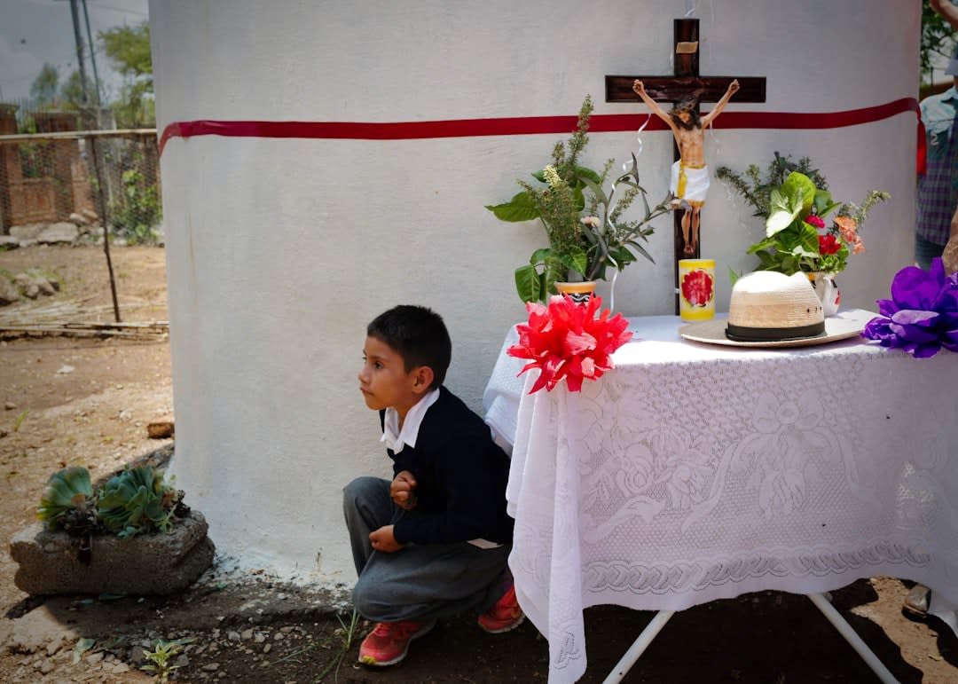 The interior of the Jesuit mission church in Huépac, Sonora, lit by candles and afternoon light through thick walls