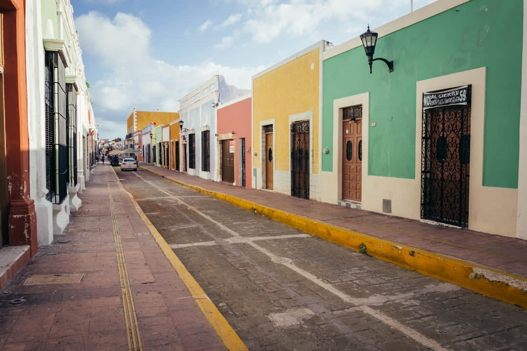 The flooded streets of Mexcaltitán in the rainy season, residents in canoes navigating between the houses, the circular island's central church visible at the end of the water-filled street, the coastal lagoon beyond