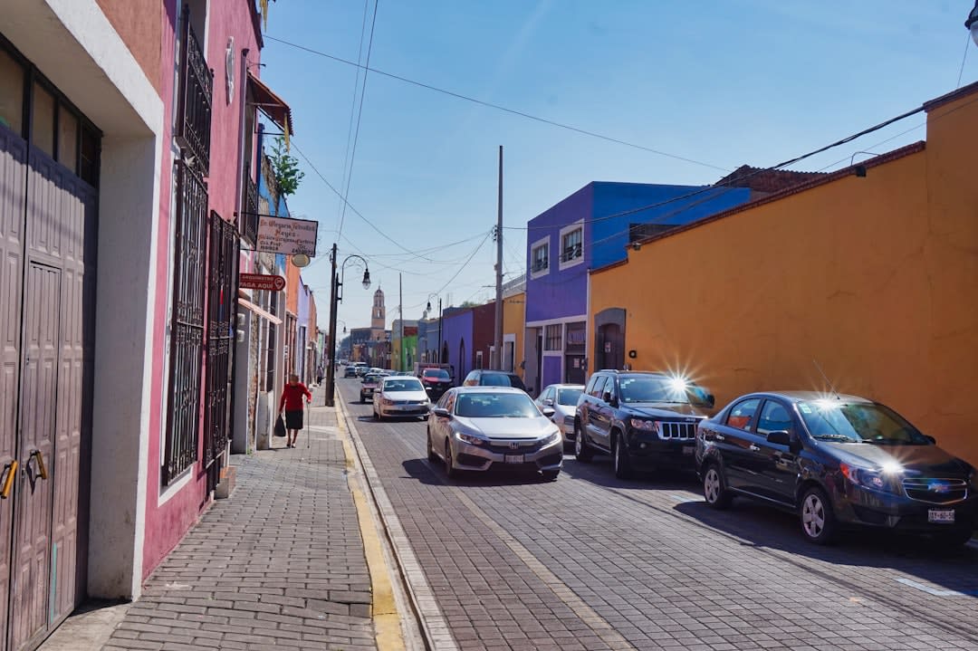 The dusty main street of Mineral de Pozos at dusk, the colonial-era church at the end of the road, ruined hacienda walls on one side, a man on horseback passing in the fading light