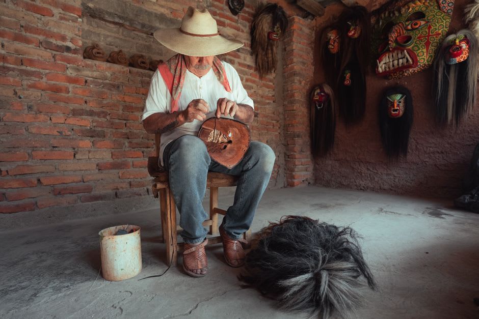 Craftsman weaving a palm-fiber sombrero on a wooden form in a Sahuayo taller