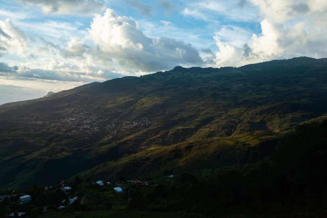 Steep foggy streets of Juquila at dusk, woodsmoke and tin roofs fading into grey mountain cloud