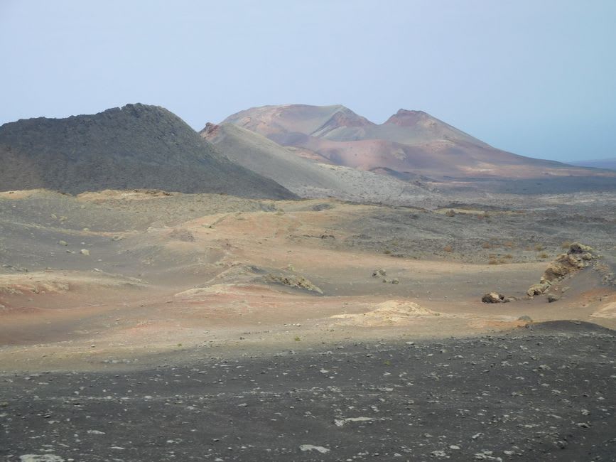 Black lava field stretching toward a volcanic cone in El Pinacate Biosphere Reserve, morning light