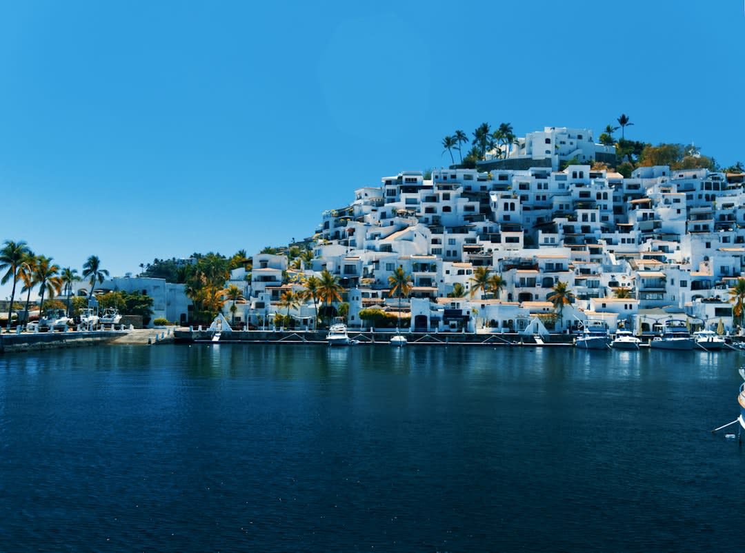 The white-walled buildings and terracotta rooftops of Taxco climbing the steep hillside, bougainvillea spilling over balconies above the narrow callejones below