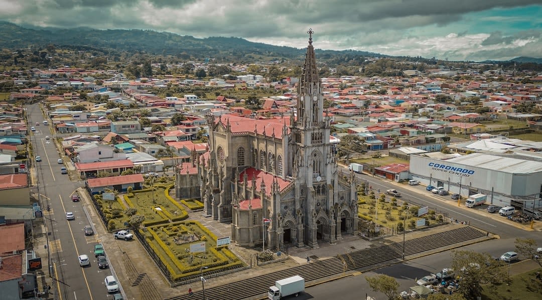 The Jardín Principal of Tecomán at dusk, locals walking the plaza near the Parroquia de la Inmaculada Concepción