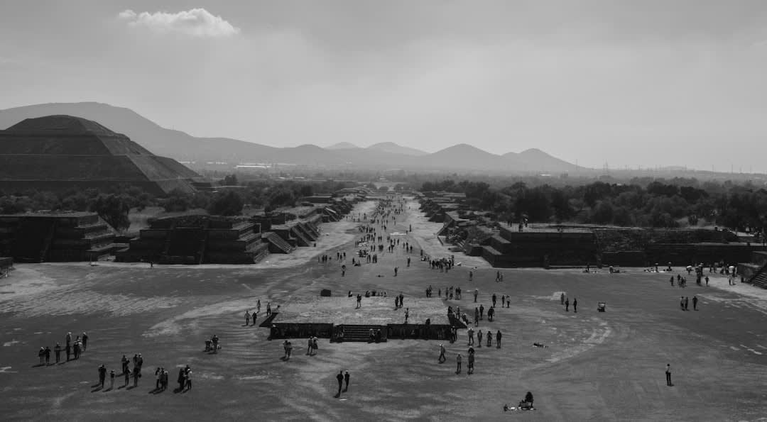 The Pyramid of the Moon at Teotihuacán seen from the Avenue of the Dead at dawn, its four stepped terraces catching the first horizontal light while the valley is still in shadow
