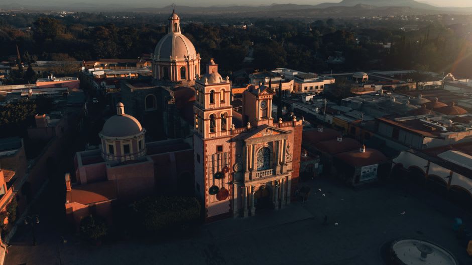 Aerial view of Tepatitlán centro with terracotta rooftops and the surrounding Los Altos hills at golden hour