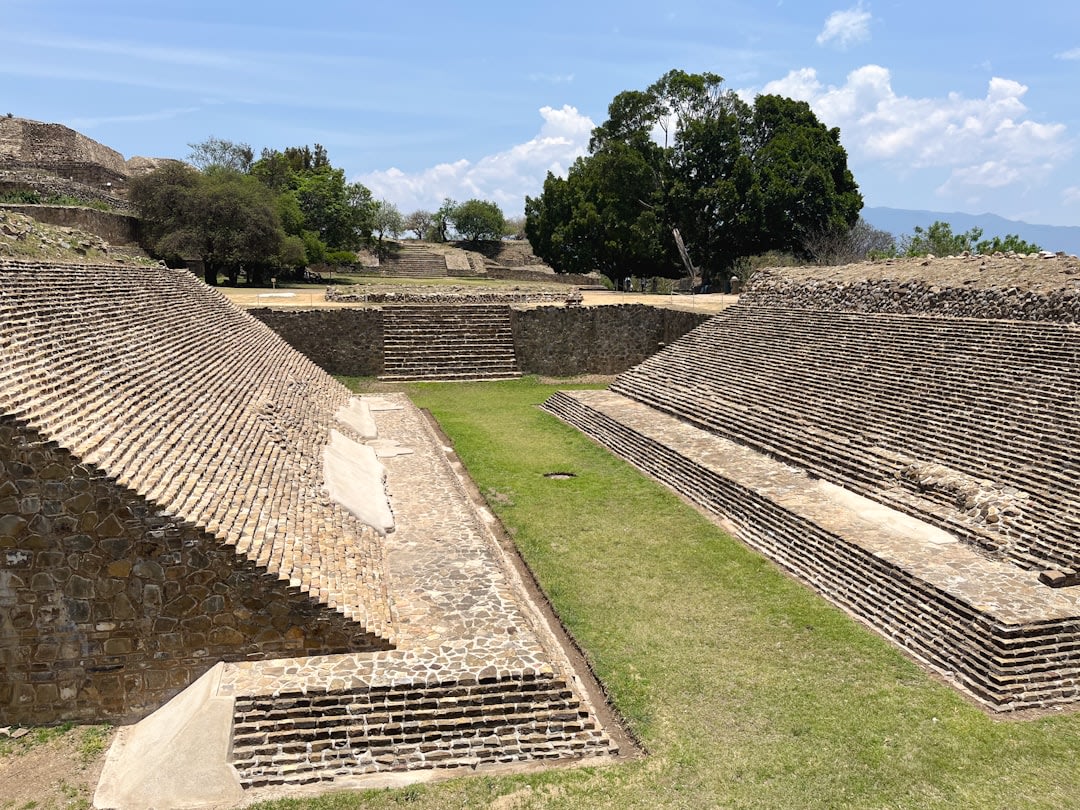 The arcaded stone portales along the plaza of Tepeapulco under a cold bright sky, agave plains visible beyond the town, the old high-plains town going quietly about its day