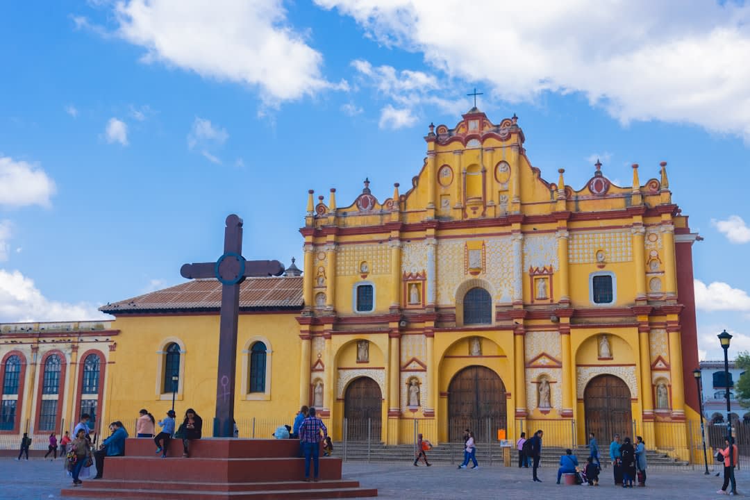 The stone façade and atrium of the Dominican convento in Tepoztlán, its fortified walls catching morning light against the basalt cliffs behind