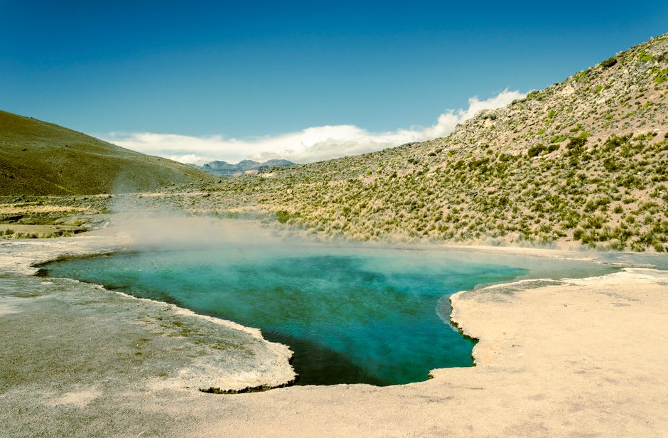 A thermal pool at one of Tequisquiapan's balnearios, steam rising slightly from warm water with old stone walls behind
