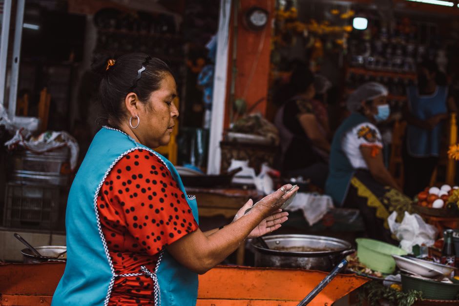 Stalls at the Tingüindín Sunday tianguis loaded with avocados and tropical fruit in the early morning light