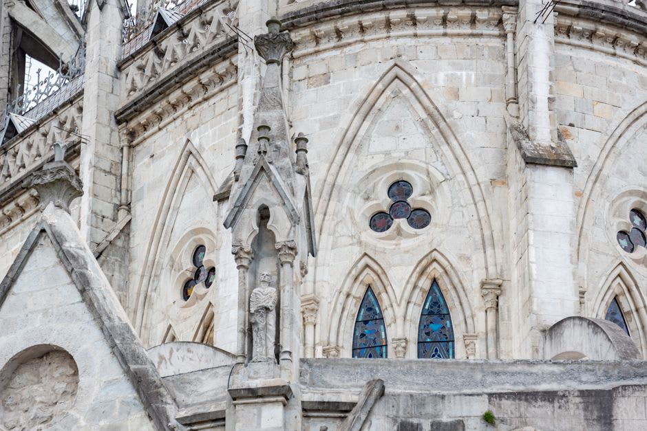 The ornate white facade of the Basílica de Ocotlán photographed from the atrium, the Churrigueresque portal in afternoon light, blue sky above the white towers
