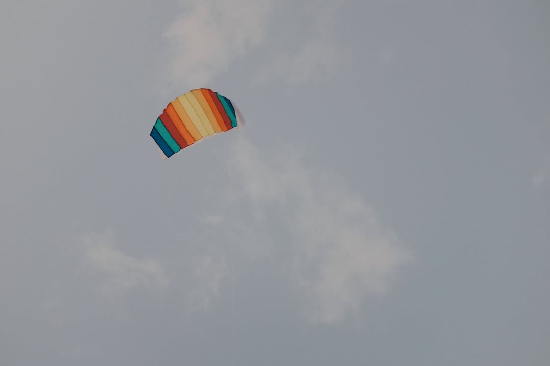 Paragliders launching from the Peña Alta ridge above Valle de Bravo, the Lago Valle de Bravo visible below with sailboats on the water, the colonial town on the shore, the pine forest hills surrounding the reservoir