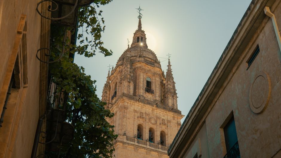 A simple fonda table on the Yuriria plaza in early evening with a bowl of caldo and the convent lit up in the background