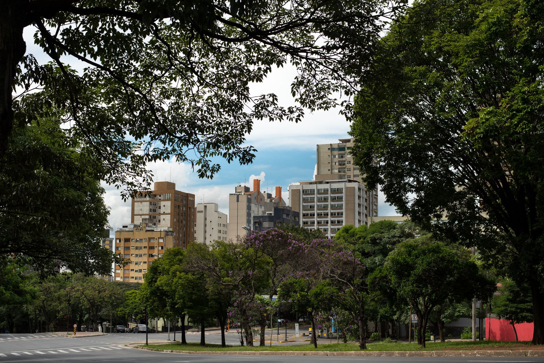 Aerial view of Belo Horizonte's grid of wide avenues stretching toward the mountains at the horizon in afternoon light