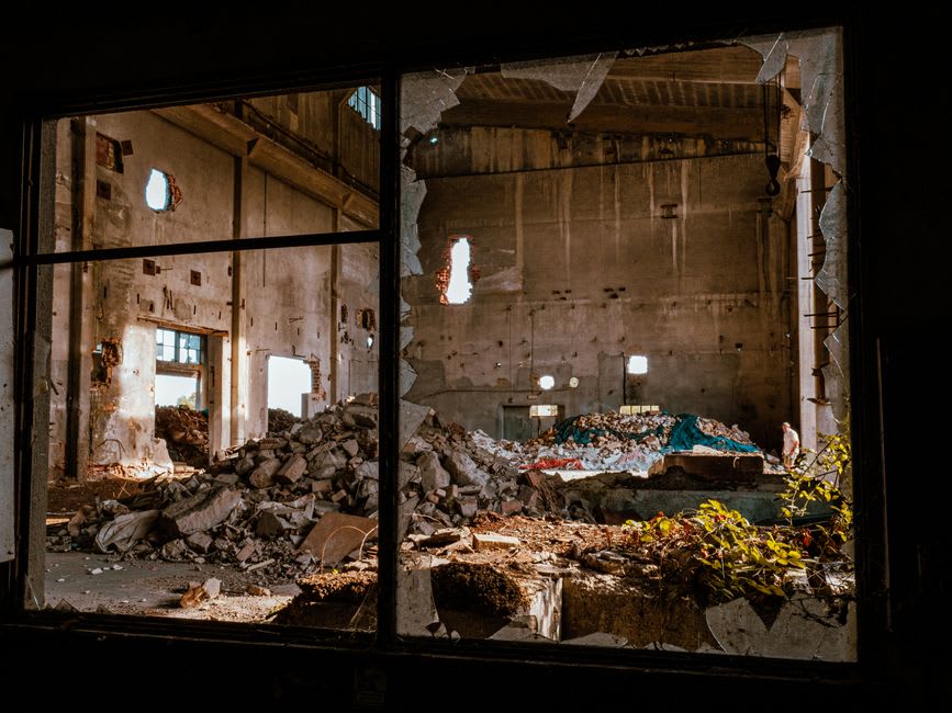 Interior of an abandoned wooden building in Bannack with sunlight streaming through a broken window