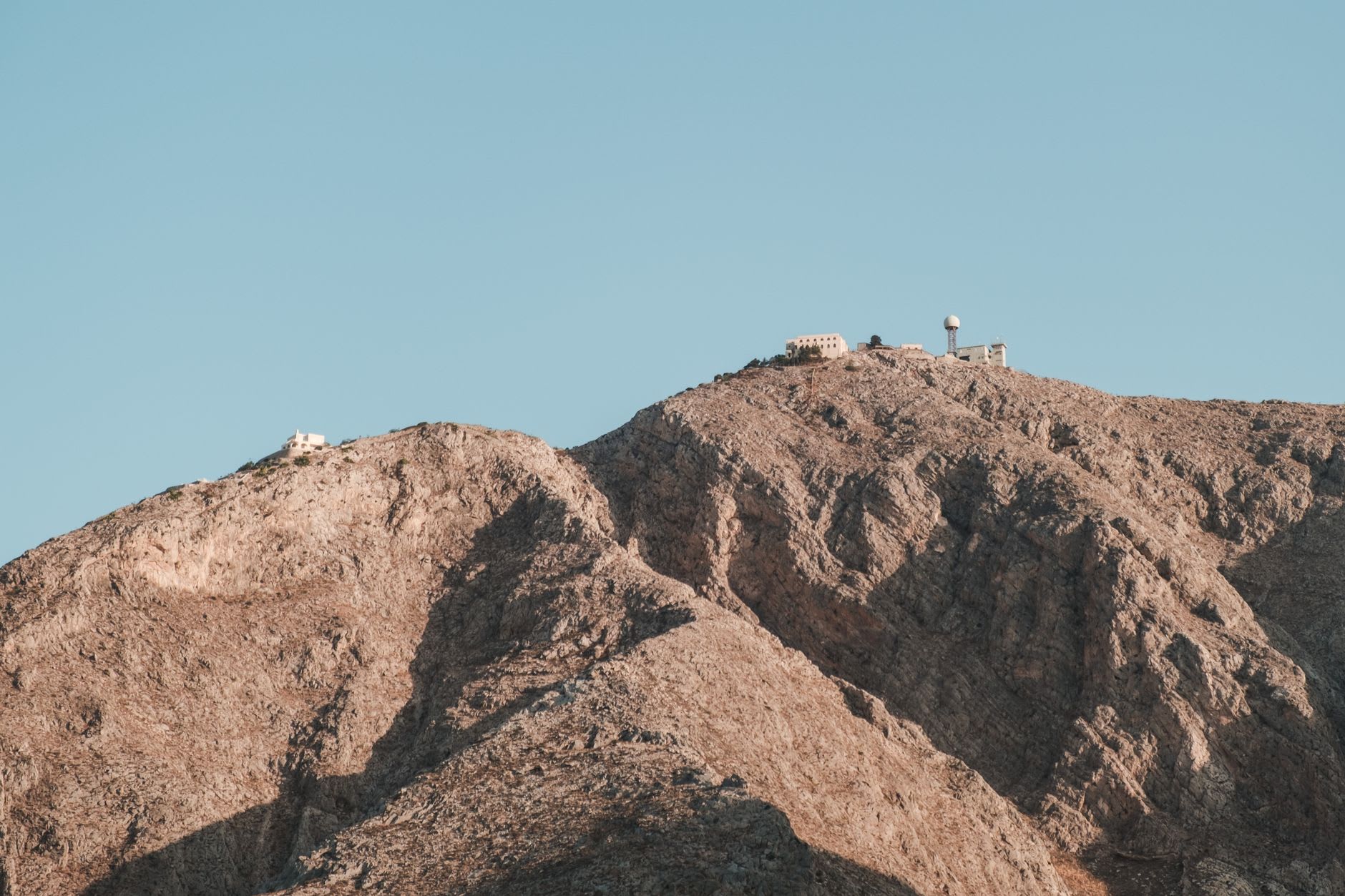 Binoculars on the observatory terrace pointed toward the ash-buried ruins of Plymouth, Montserrat's abandoned capital, in the distance below the volcano