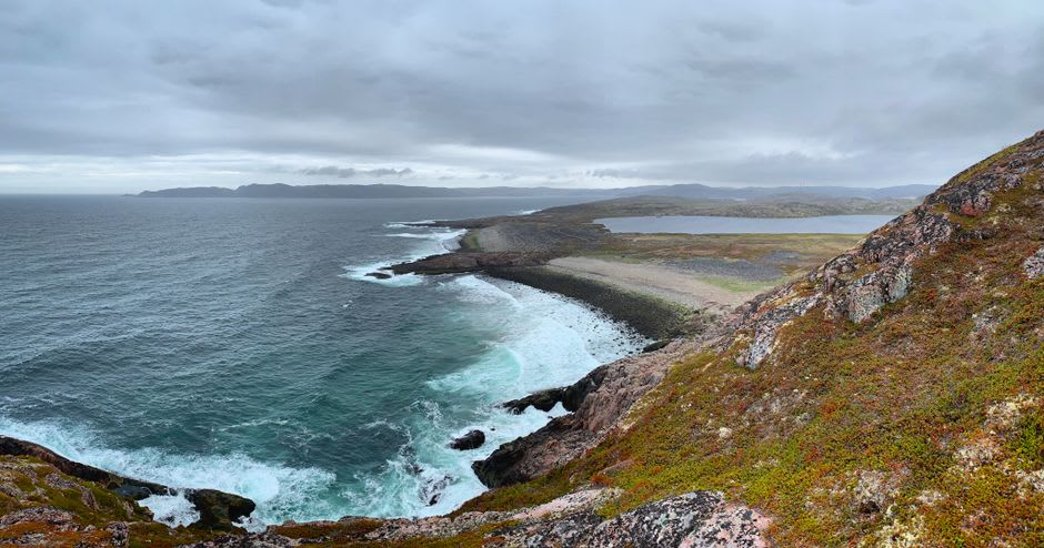 Barents Sea coastline cliffs with no trees visible, only tundra grass and rock on Rybachy Peninsula