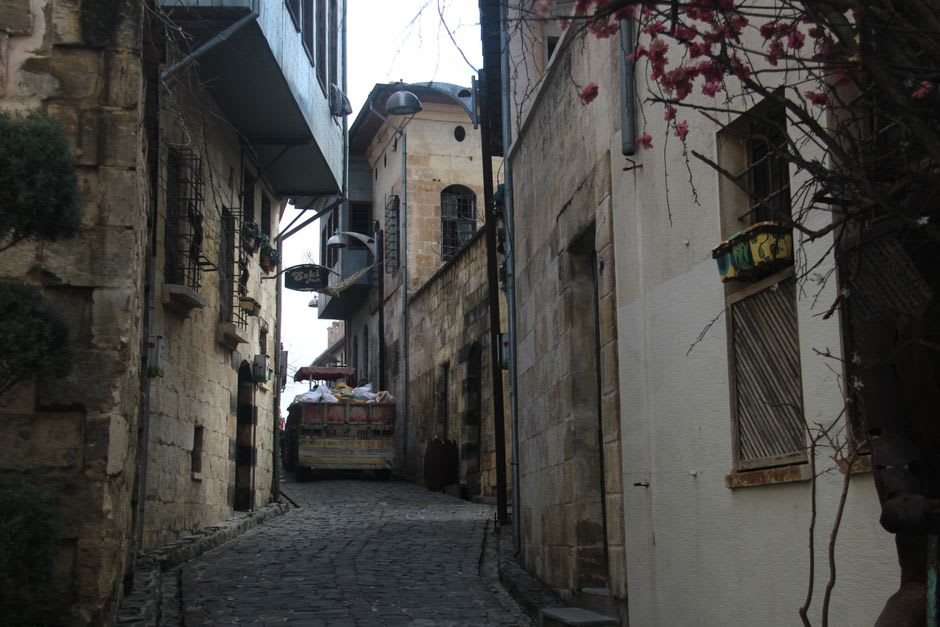 Une ruelle étroite dans la vieille ville de Ma'an, des maisons en briques de terre et en pierre serrées les unes contre les autres avec du linge tendu entre les bâtiments