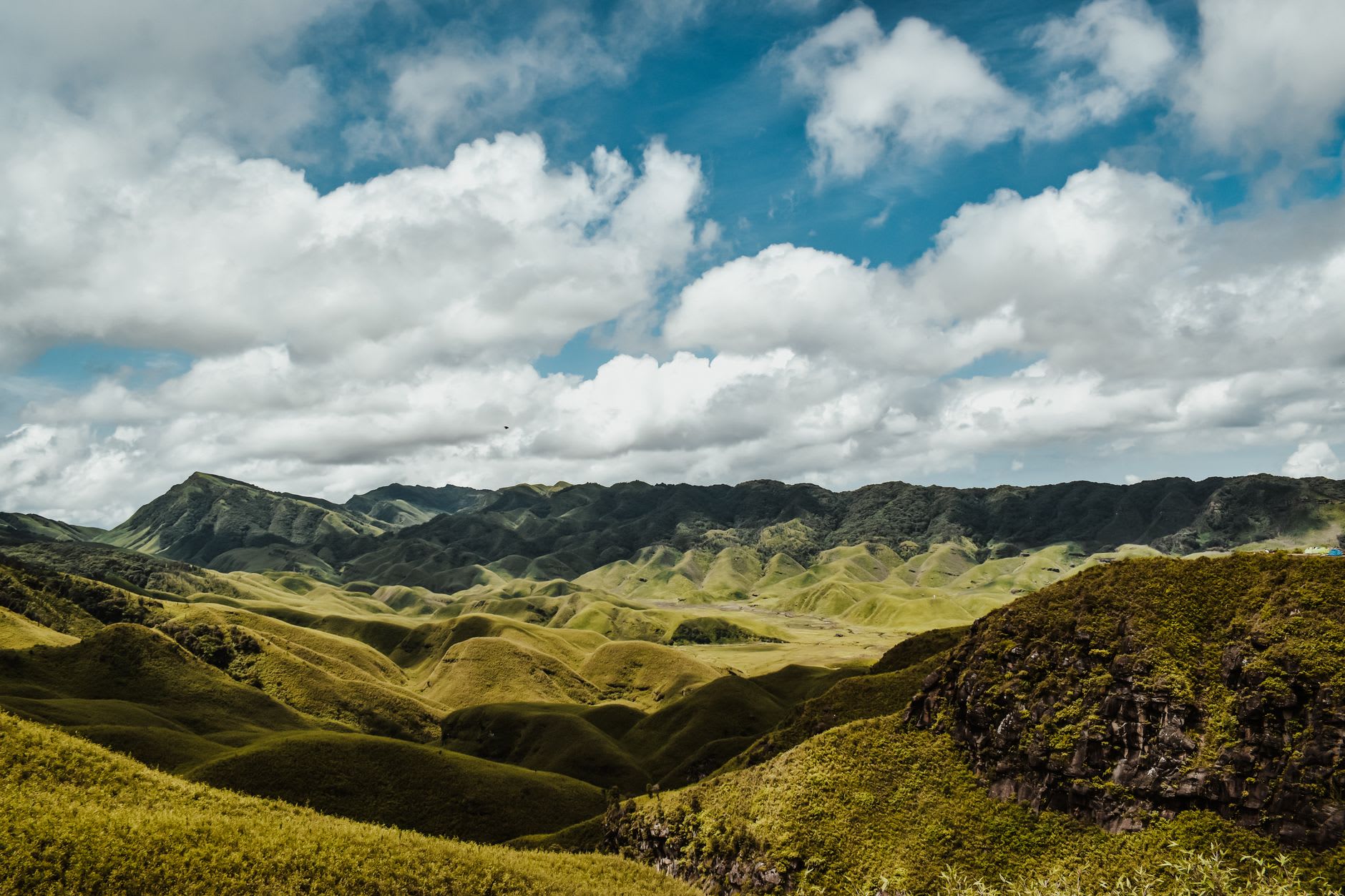 Dzükou Valley river winding through copper autumn grasslands with bare ridgelines above in November light