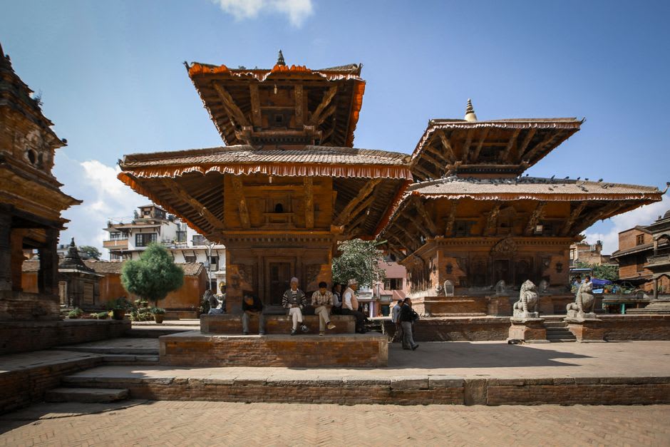 Ancient stone statue of Garuda kneeling in prayer at the entrance to Changu Narayan temple