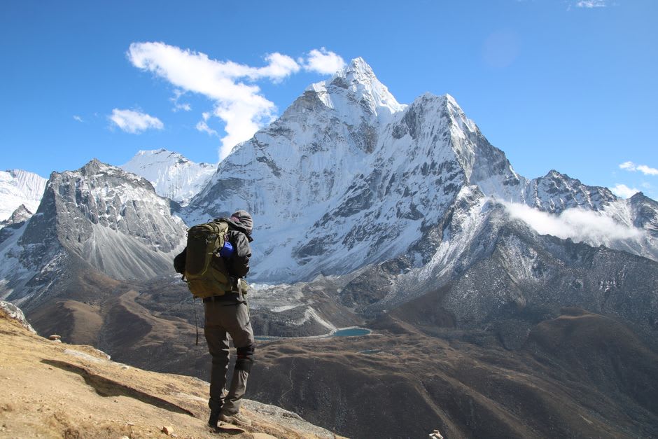 Trekkers ascending the ridge trail of Nangkartshang Peak above Dingboche with mountain views opening up