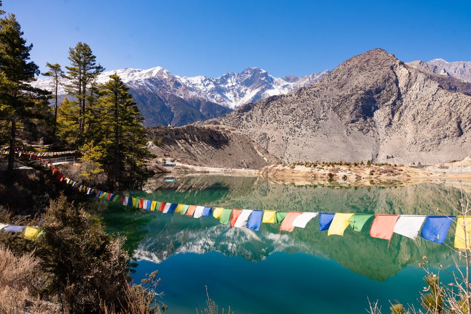 Lecho del río Kali Gandaki y paredes del cañón vistas desde Kagbeni en la hora dorada, con campos de cebada en primer plano
