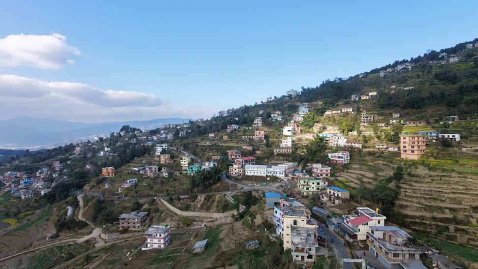 Layered Himalayan peaks catching the first pink light of sunrise, viewed from a guesthouse rooftop in Nagarkot