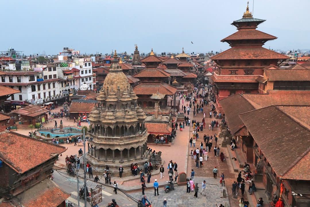Cremation ghats along the Bagmati River at Pashupatinath, smoke rising against the temple's tiered pagoda roofs