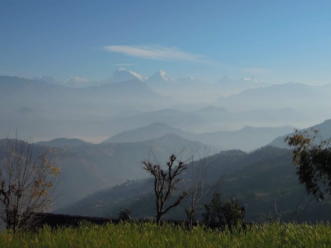 Foule de randonneurs en silhouette regardant le lever du soleil depuis la plateforme d'observation de Sarangkot, la chaîne des Annapurnas émergeant dans la lumière d'avant l'aube