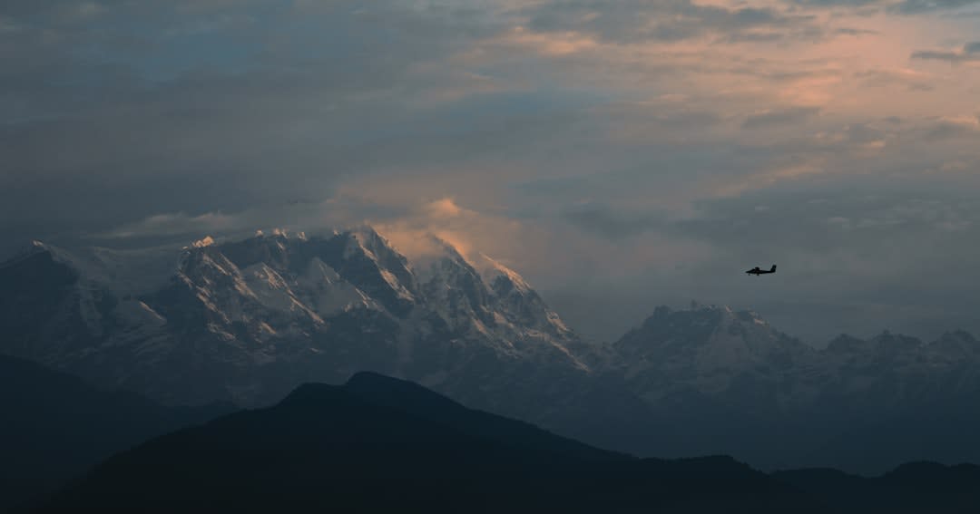 Vue panoramique depuis la crête de Sarangkot au lever du soleil montrant la vallée en terrasses de Pokhara encore dans l'ombre sous les sommets illuminés de l'Annapurna et du Machapuchare