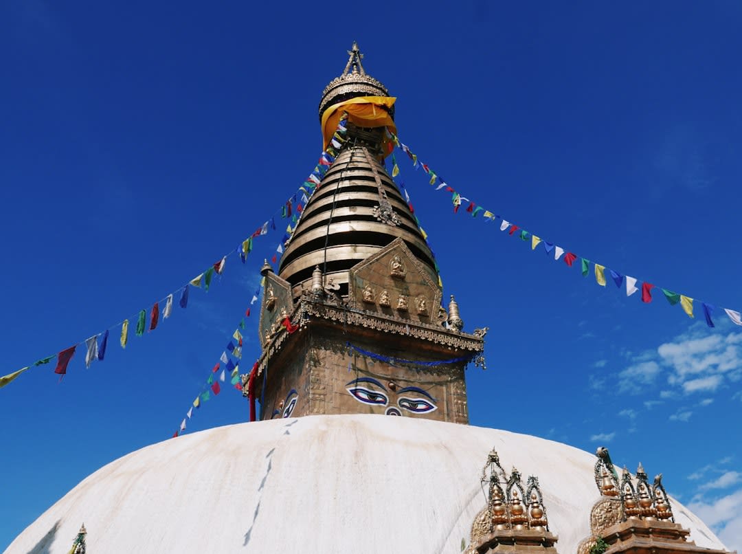 Vue panoramique sur la vallée de Katmandou embrumée depuis le sommet de Swayambhunath, flèches de temples et toits s'étendant jusqu'à l'horizon