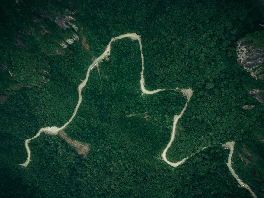 A mountain road winding through dense green forest between Thio and Canala
